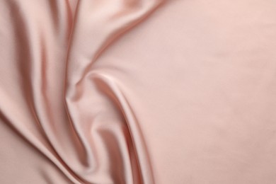 Crumpled pink silk fabric as background, top view. Space for text