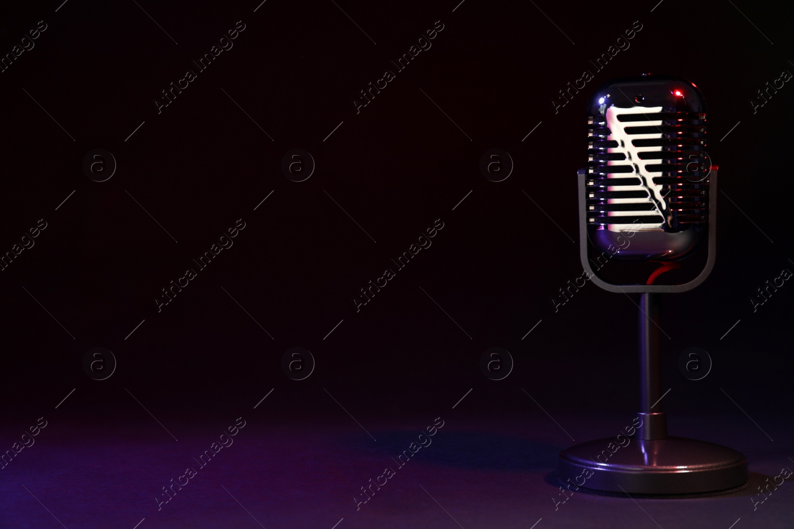 Photo of Retro microphone on black background. Space for text