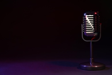 Photo of Retro microphone on black background. Space for text