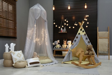 Photo of Cozy kids room interior with play tents and toys