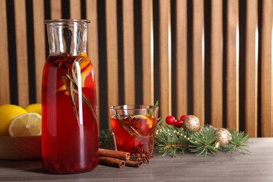 Photo of Aromatic punch drink and Christmas decor on wooden table, space for text