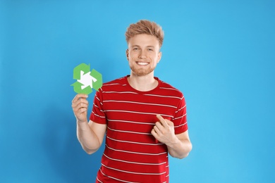 Young man with recycling symbol on blue background