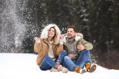 Photo of Couple spending time outdoors on snowy day. Winter vacation