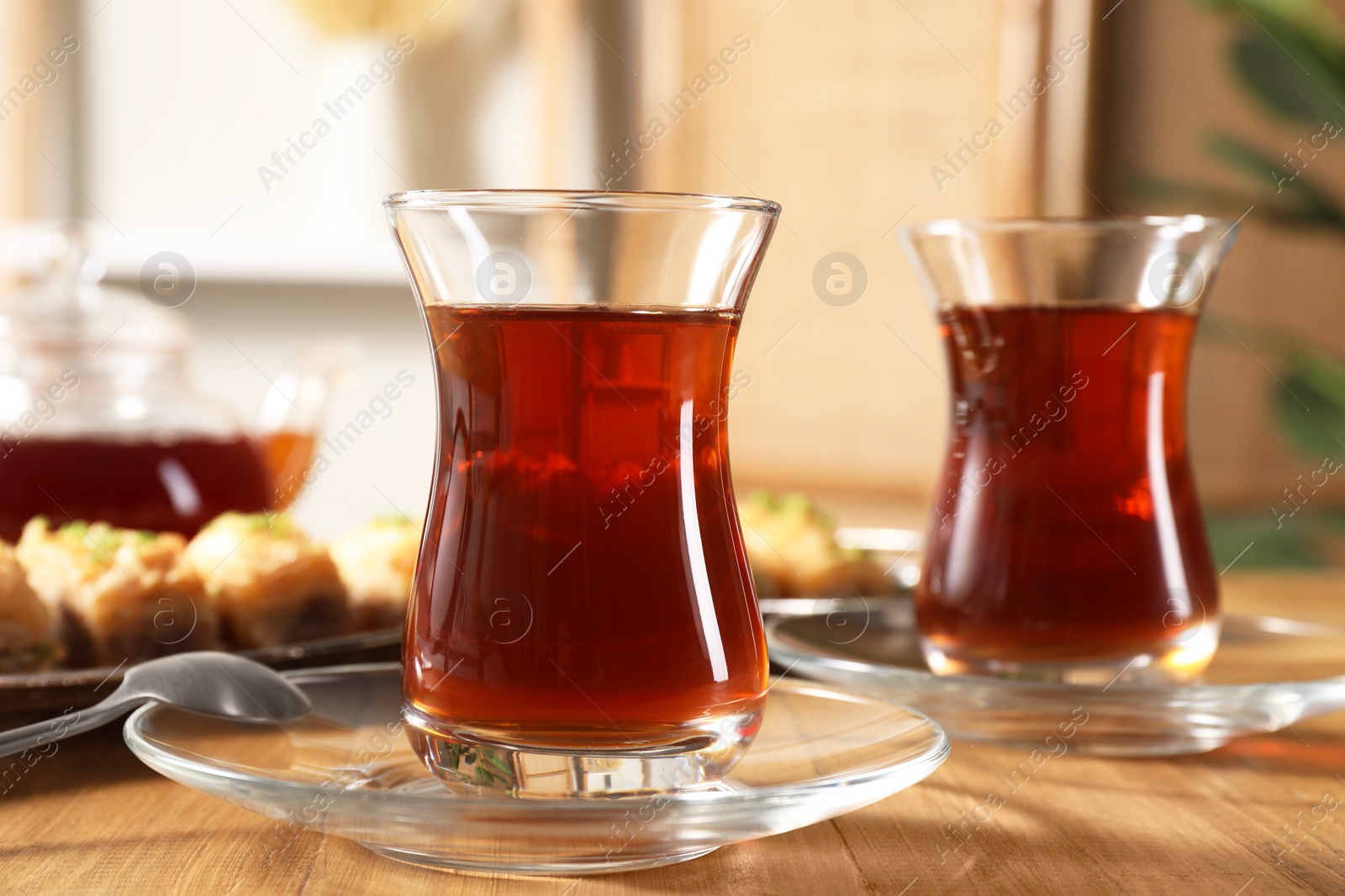 Photo of Traditional Turkish tea in glasses on wooden table, closeup