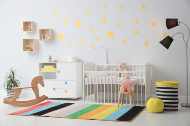 Stylish baby room interior with crib and toys