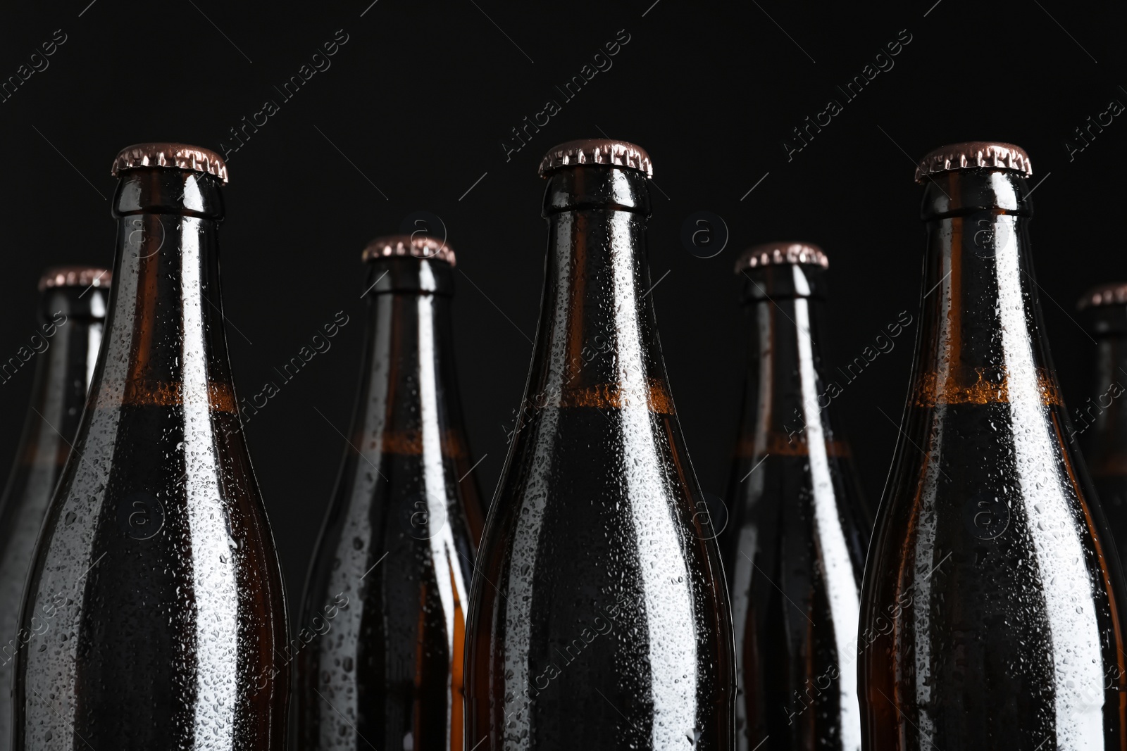 Photo of Bottles of beer on black background, closeup