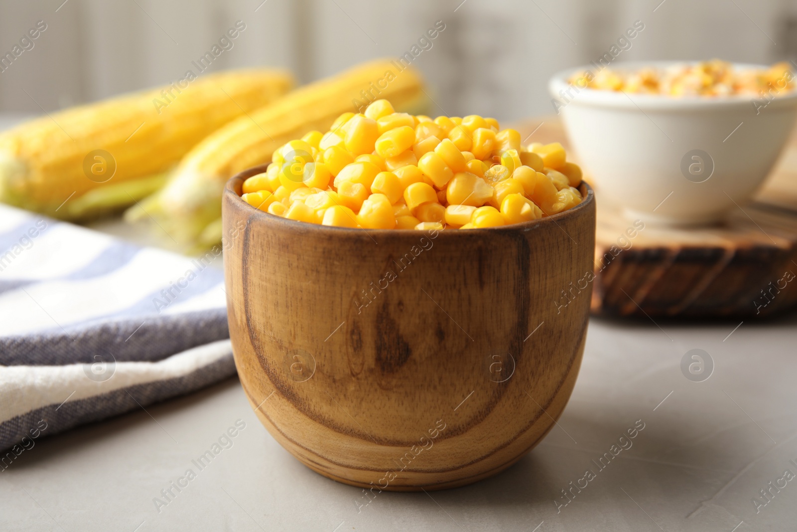 Photo of Bowl with corn kernels on grey table