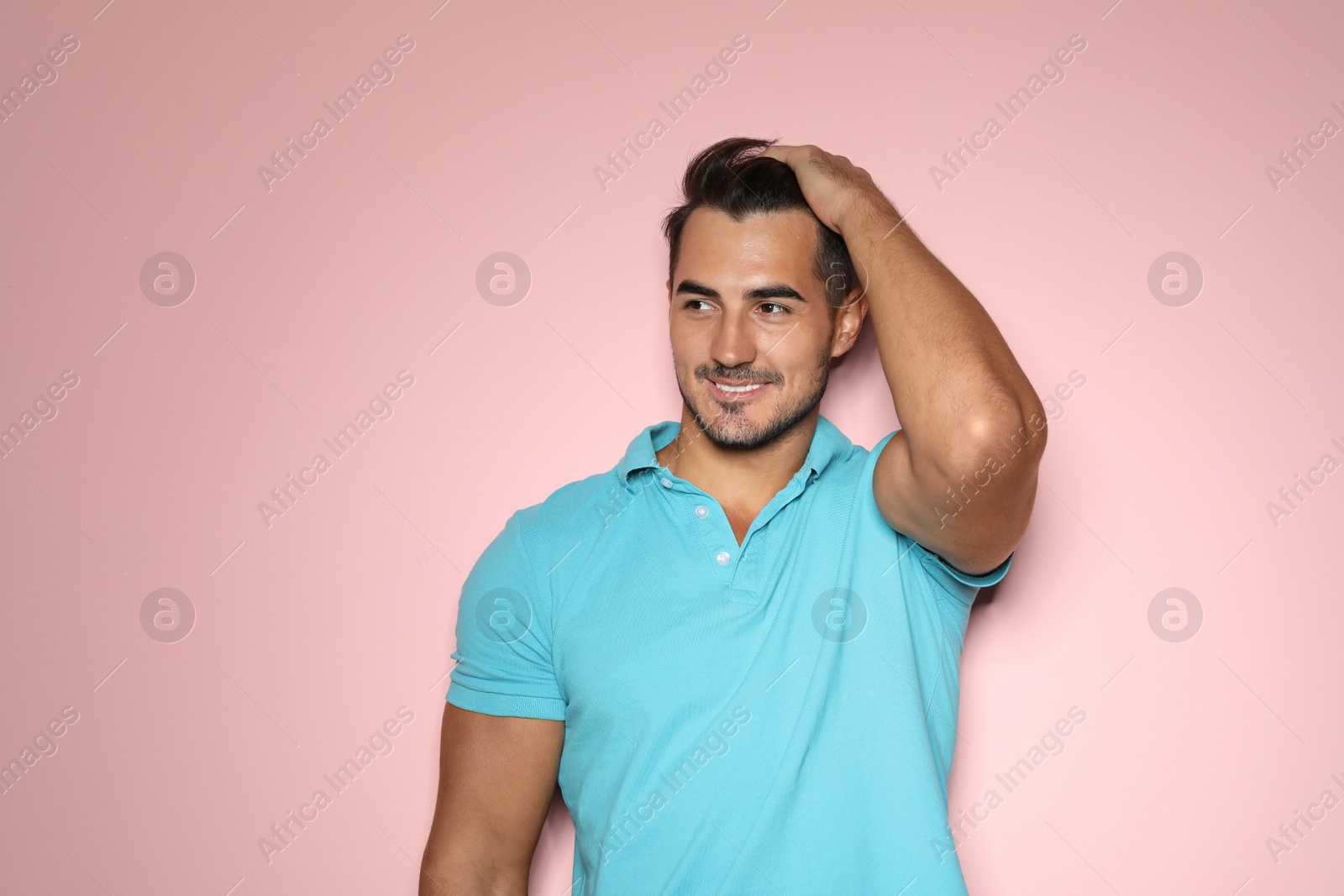 Photo of Young man with trendy hairstyle posing on color background