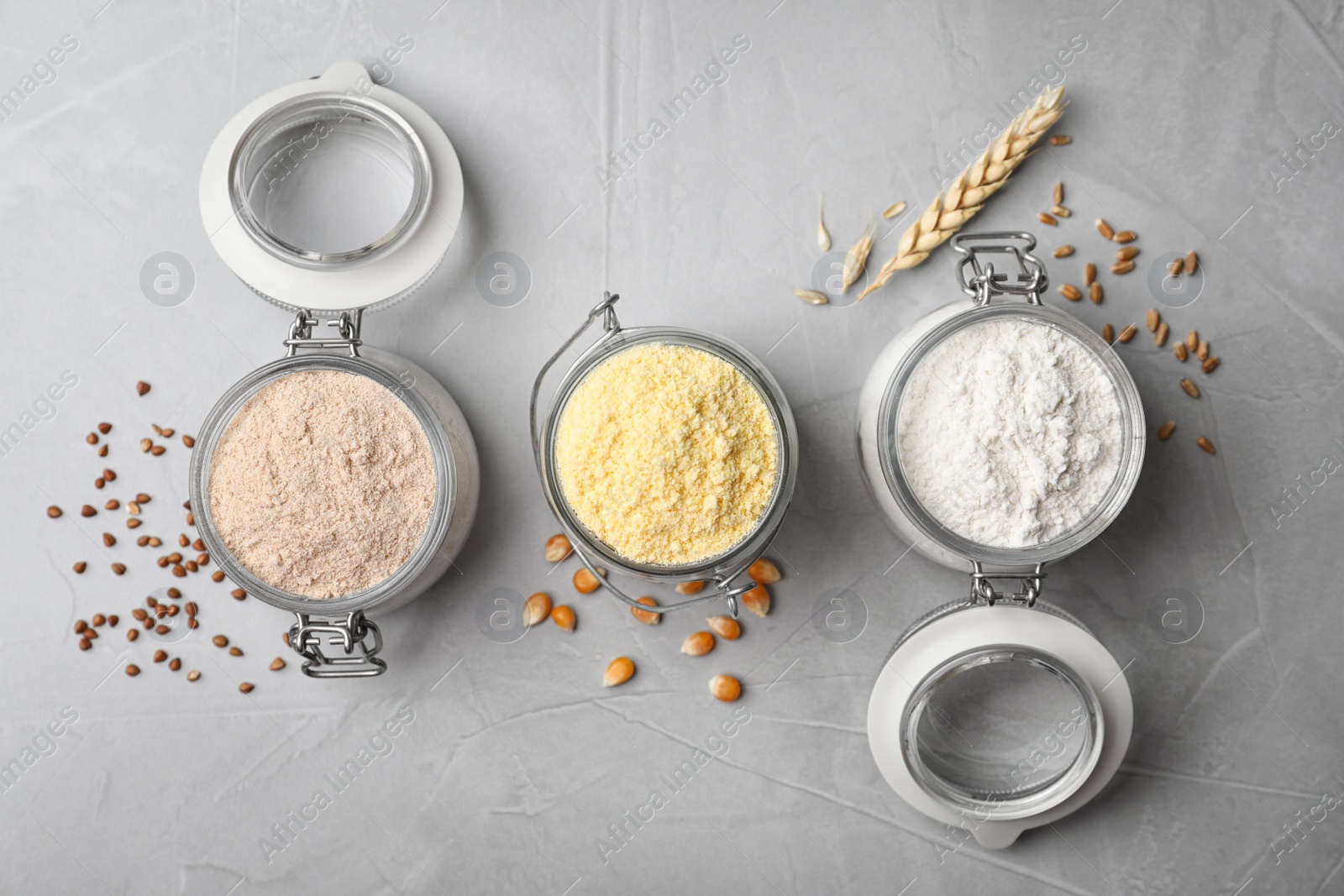 Photo of Jars with different types of flour on gray background