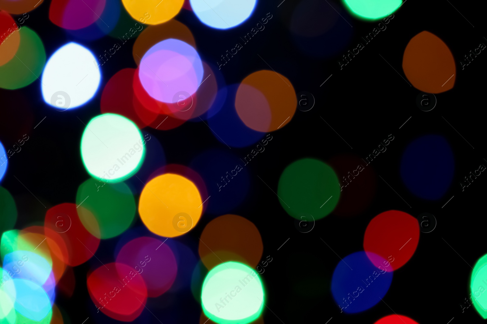 Photo of Blurred view of colorful lights on black background. Bokeh effect