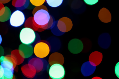 Blurred view of colorful lights on black background. Bokeh effect