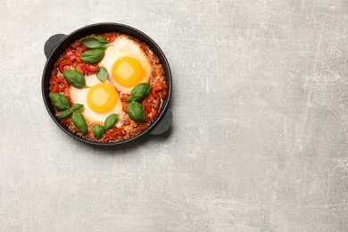 Photo of Delicious Shakshuka on light grey table, top view. Space for text