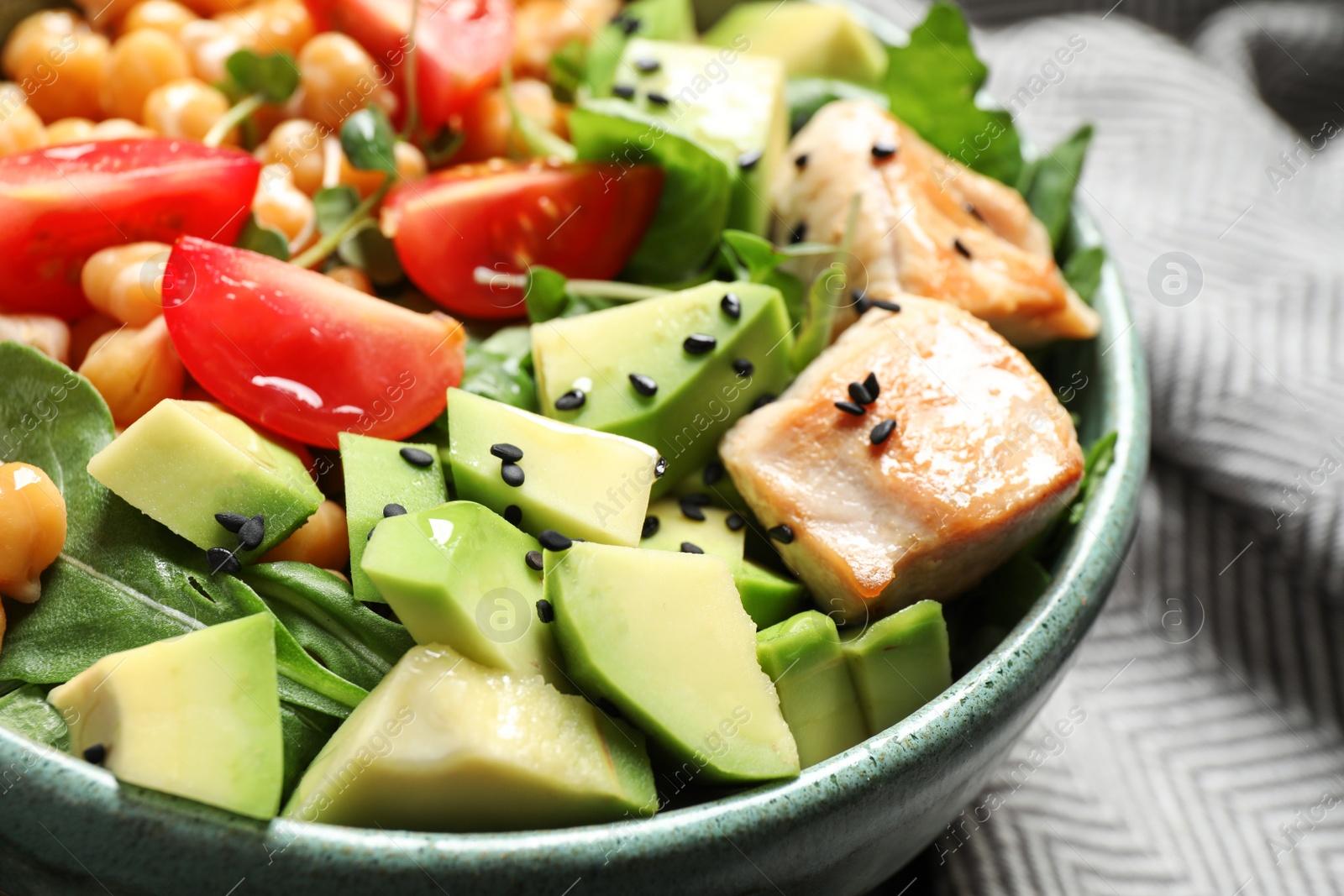 Photo of Delicious avocado salad with chickpea in bowl, closeup