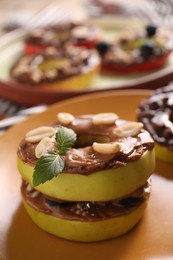 Photo of Fresh apples with nut butter and peanuts on plate, closeup