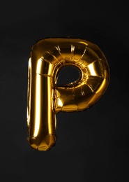 Photo of Golden letter P balloon on black background