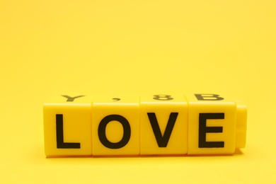 Photo of Cubes with word LOVE on yellow background