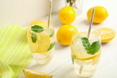 Photo of Cool freshly made lemonade and fruits on white wooden table