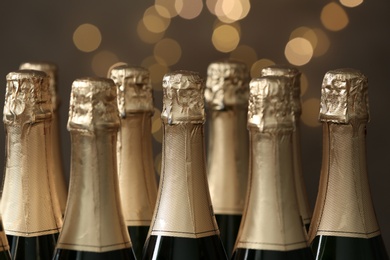 Many bottles of champagne on blurred background, closeup