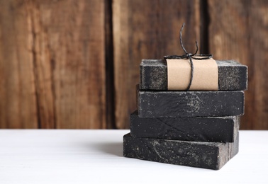 Photo of Natural tar soap on white table. Space for text