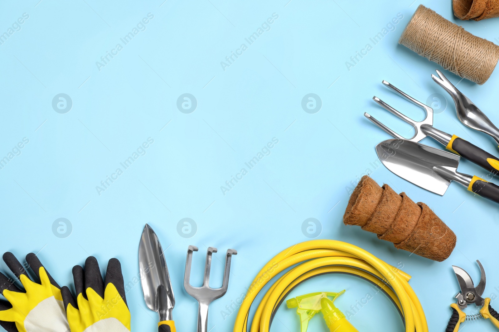 Photo of Flat lay composition with gardening tools on light blue background, space for text