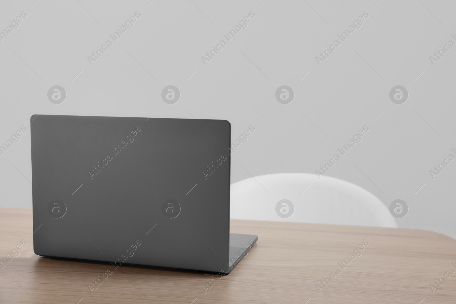 Photo of Stylish modern laptop on wooden table indoors. Space for text