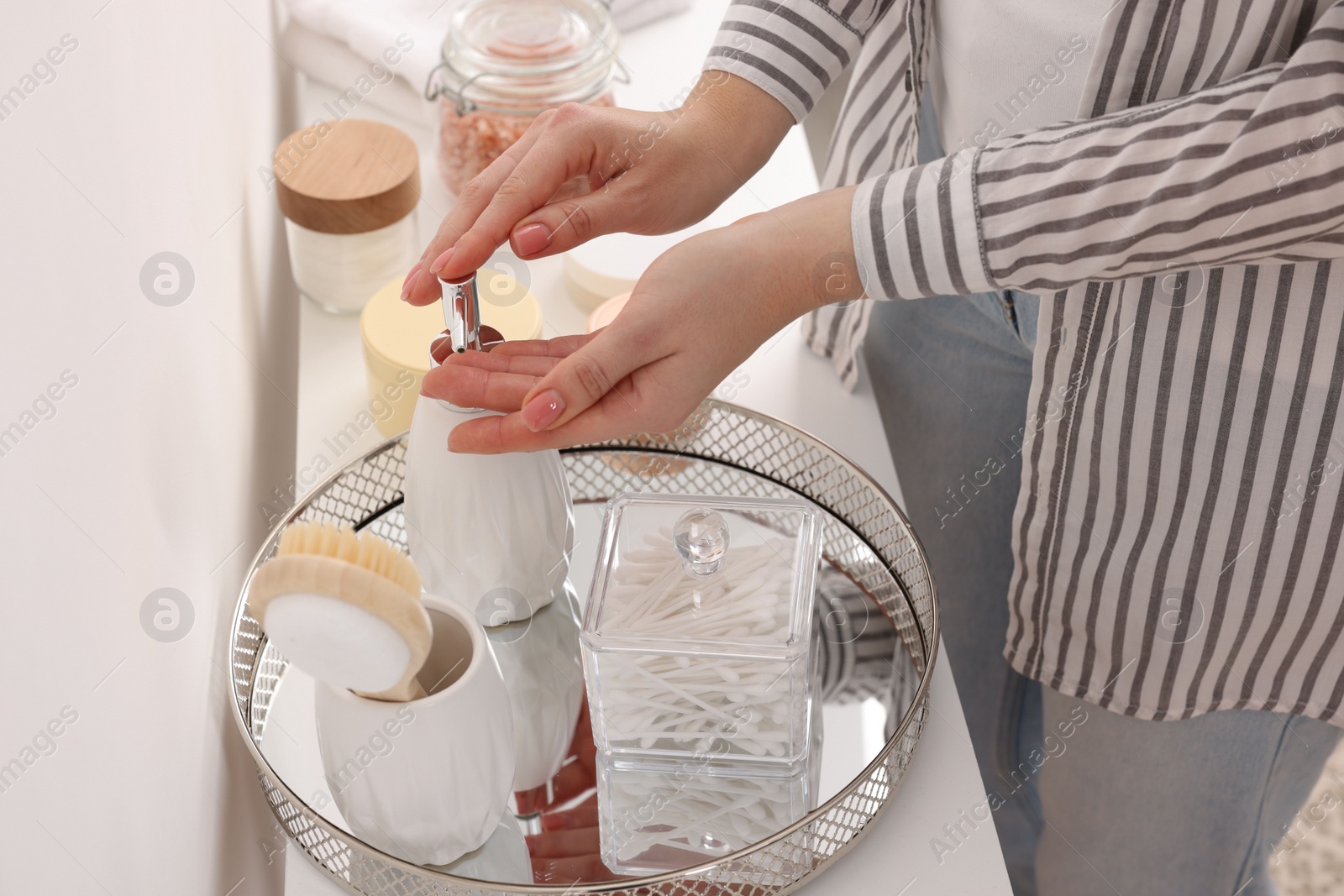 Photo of Bath accessories. Woman applying soap on her hand indoors, closeup