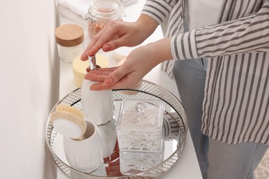 Photo of Bath accessories. Woman applying soap on her hand indoors, closeup