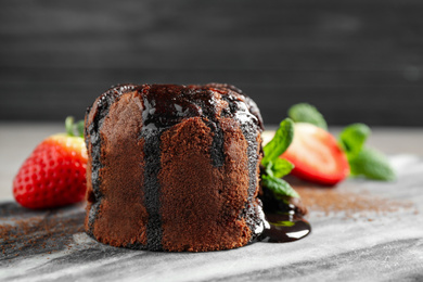 Photo of Delicious warm chocolate lava cake on marble board, closeup