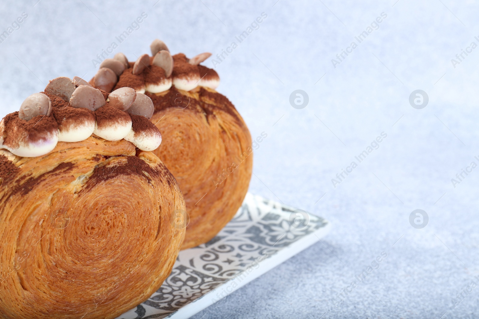 Photo of Tasty puff pastry. Supreme croissants with chocolate chips and cream on grey background, closeup. Space for text