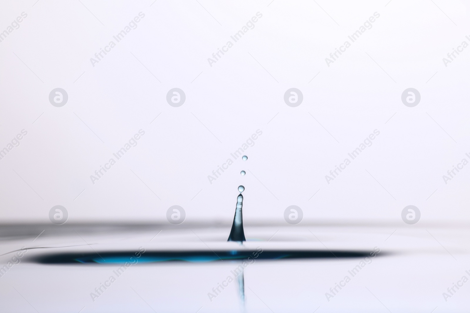 Photo of Splash of clear water with drops on light background, closeup