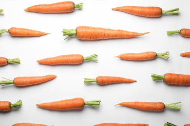 Flat lay composition with fresh carrots on color background