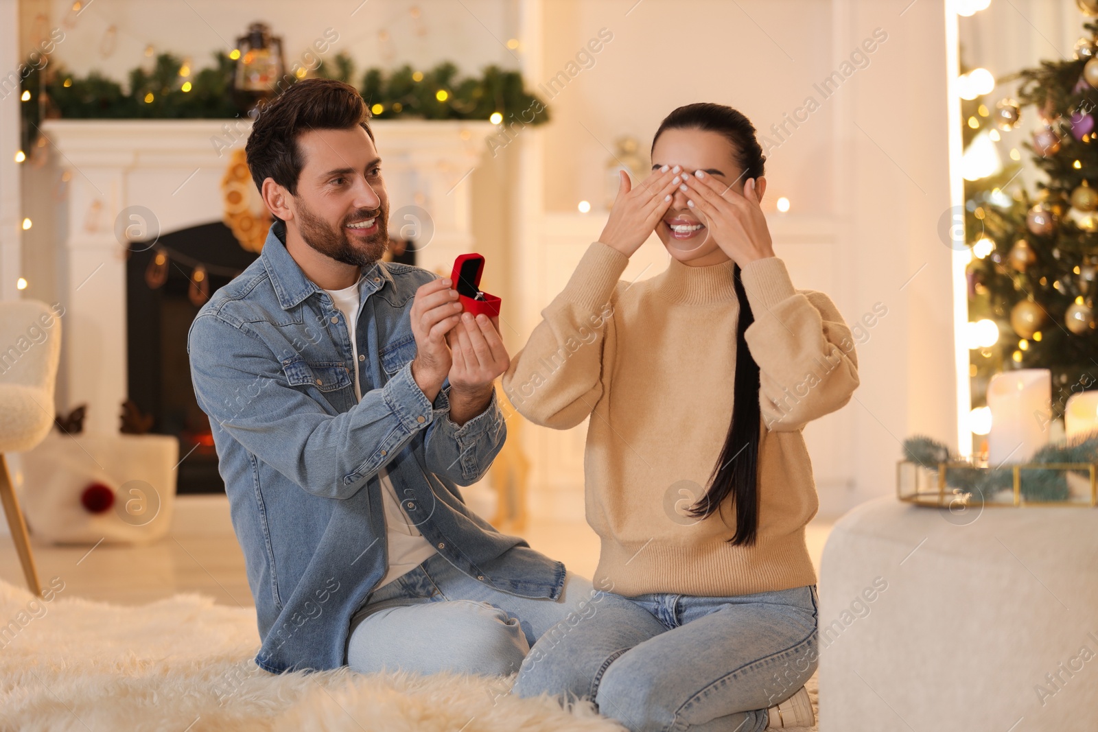 Photo of Making proposal. Man with engagement ring surprising his girlfriend at home on Christmas