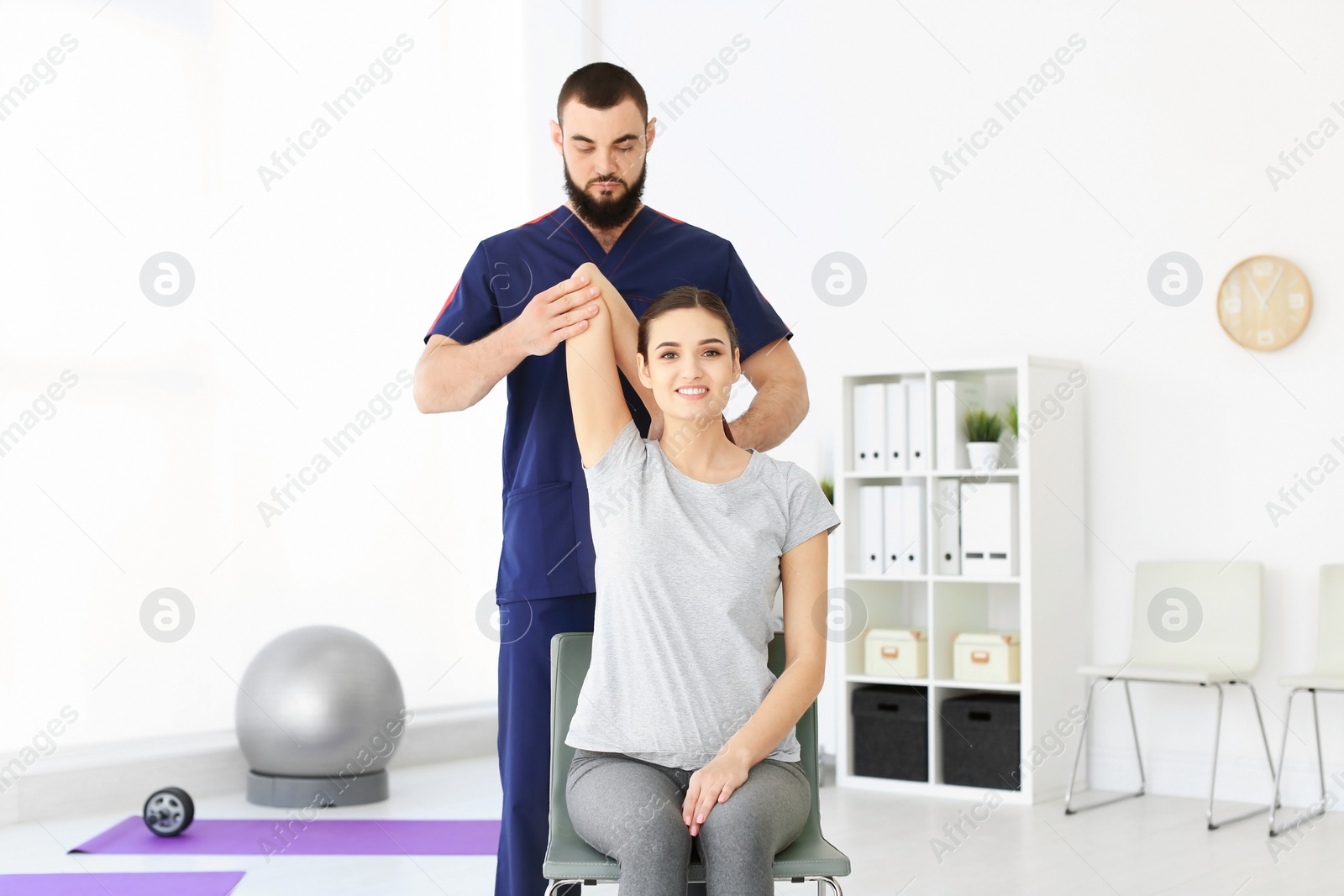 Photo of Physiotherapist working with young female patient in clinic