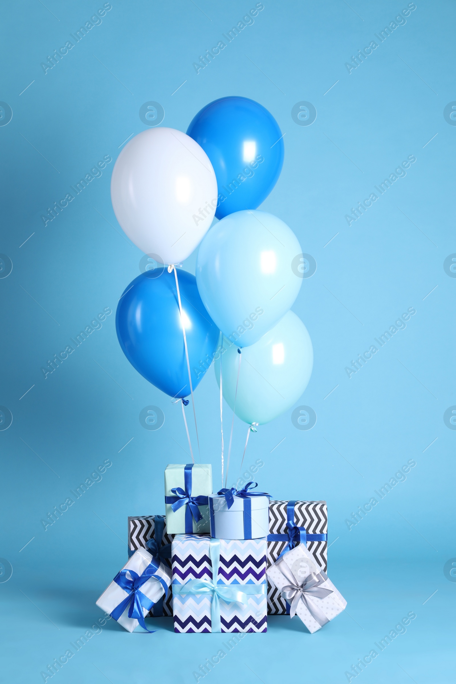 Photo of Many gift boxes and balloons on light blue background