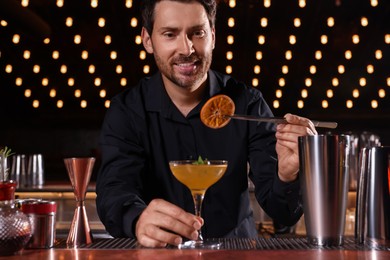 Photo of Bartender preparing fresh alcoholic cocktail in bar