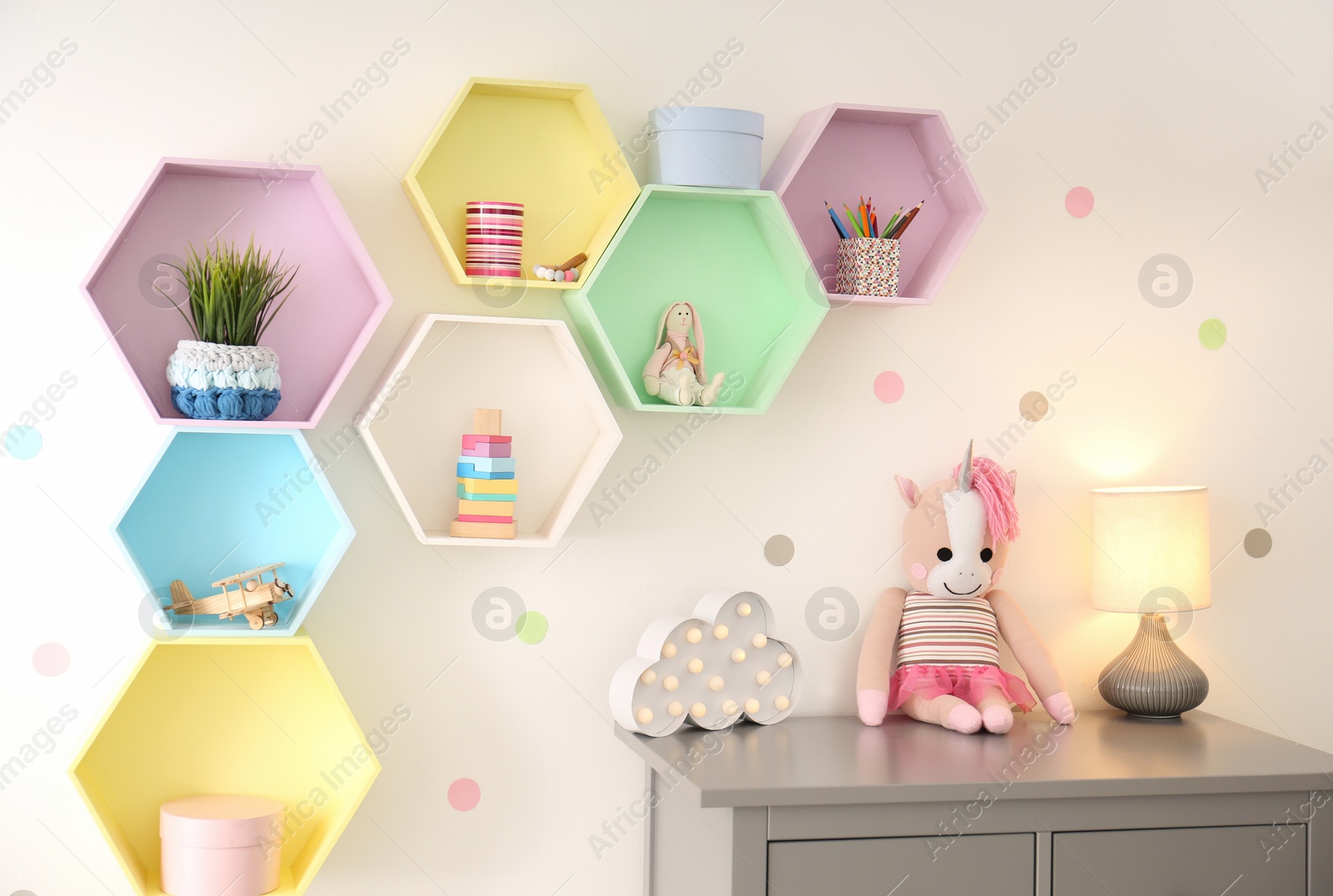 Photo of Bright colorful shelves on light wall in room. Interior design