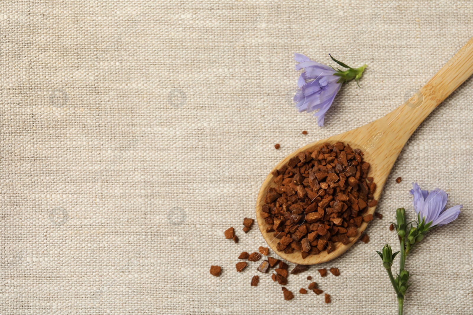 Photo of Spoon of chicory granules and flowers on sackcloth, flat lay. Space for text