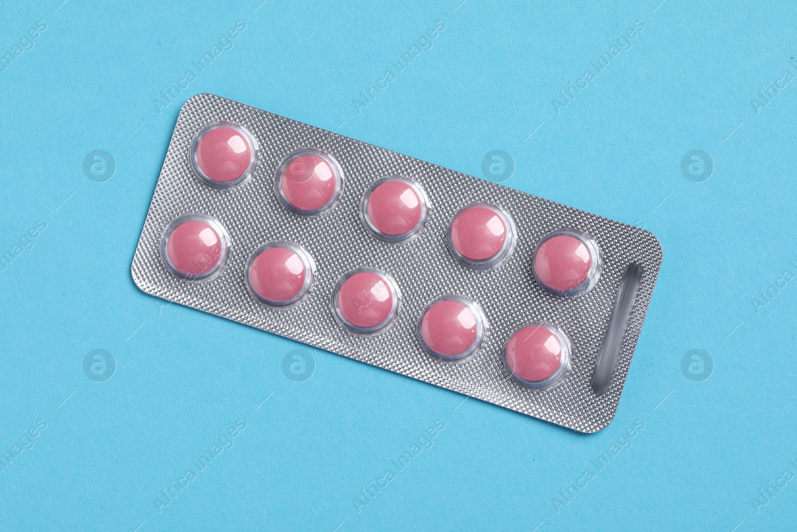 Photo of Pills in blister on blue background, top view