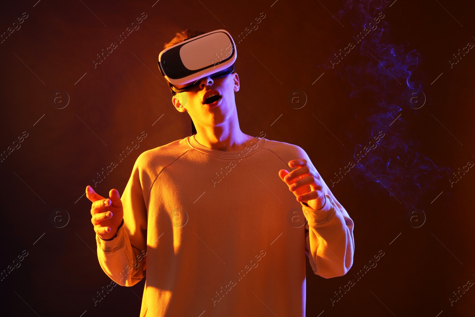 Photo of Young man with virtual reality headset on brown background