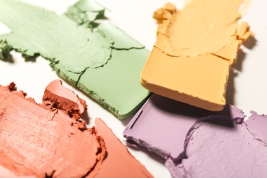 Samples of different color correcting concealers on white background, closeup