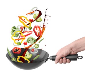 Image of Man tossing ingredients in wok on white background, closeup