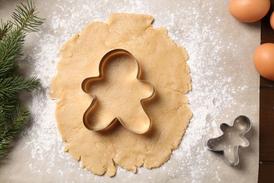 Making Christmas cookies. Raw dough and cutters on wooden table, flat lay