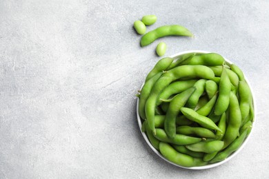 Photo of Green edamame beans in pods on light grey table, flat lay. Space for text