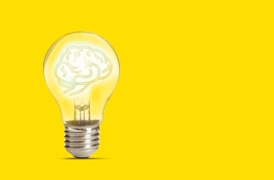 Image of Lamp bulb with human brain inside on yellow background, space for text. Idea generation