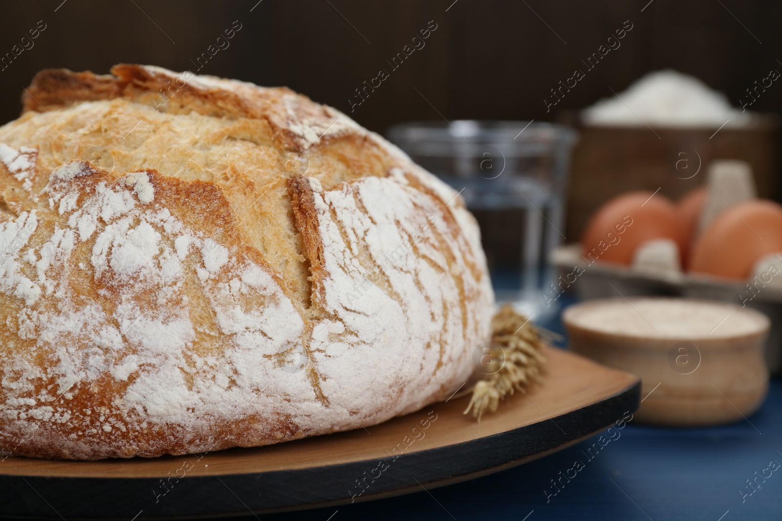 Photo of Freshly baked bread on blue wooden table, closeup. Space for text