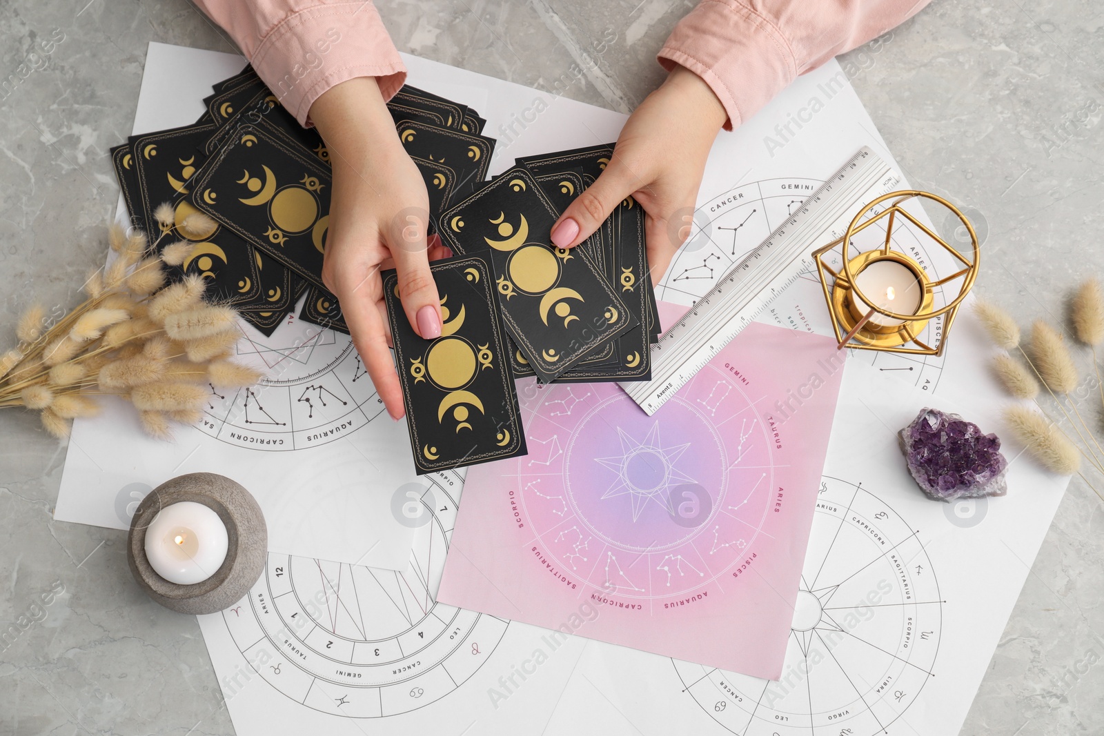 Photo of Woman using tarot cards at table, top view. Astrological predictions