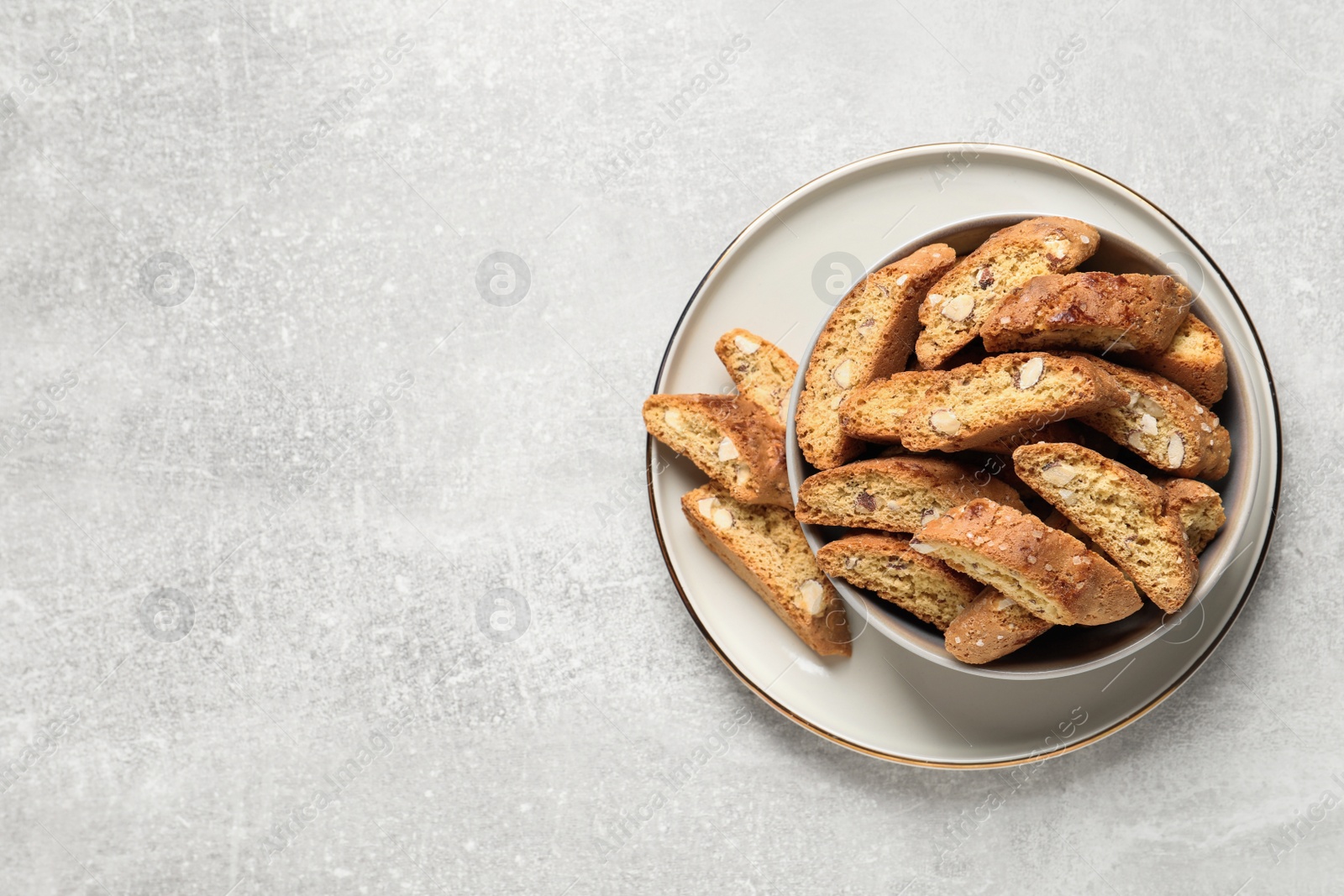 Photo of Traditional Italian almond biscuits (Cantucci) on light table, top view. Space for text