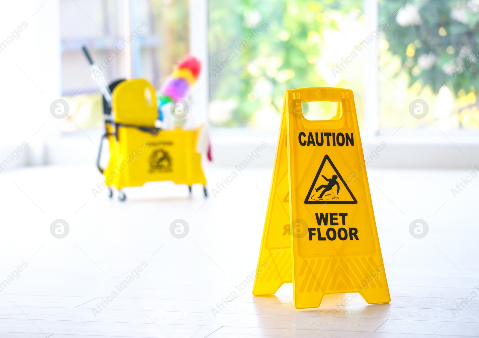 Photo of Safety sign with phrase Caution wet floor, indoors. Cleaning service