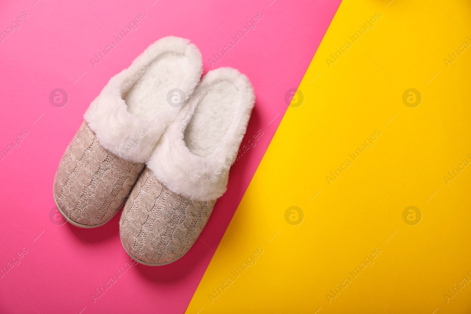 Photo of Pair of beautiful soft slippers on colorful background, top view. Space for text