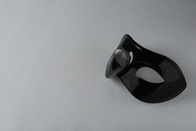 Photo of Black theatre mask on grey background, space for text